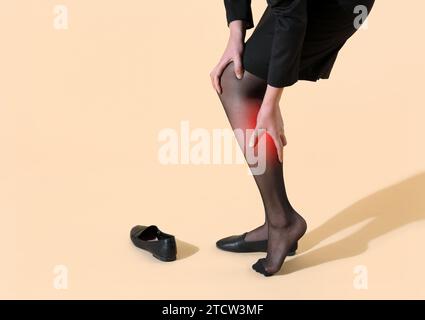 Bürofrau in Strümpfen und Rock hält ihr Knie Stockfoto