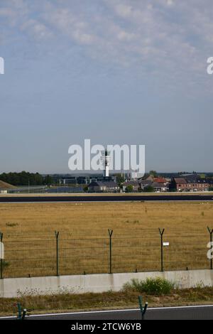 Blick auf den Kontrollturm des internationalen Flughafens Brüssel von der anderen Seite der Start- und Landebahn 25L Stockfoto