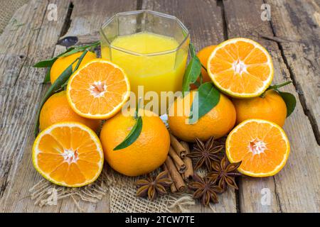 Orangensaft und einige frische Früchte auf hölzernem Hintergrund Stockfoto