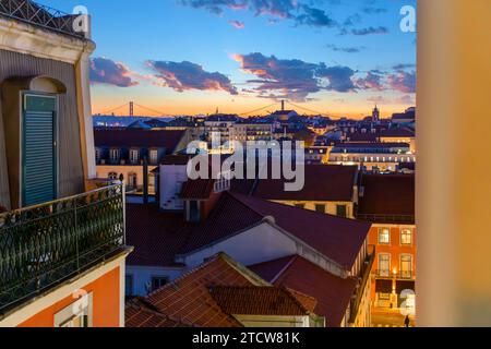 Ein farbenfroher, dramatischer Sonnenuntergangshimmel über der Stadtlandschaft und der Brücke Ponte 25 de Abril aus dem mittelalterlichen Viertel Alfama in Lissabon, Portugal. Stockfoto