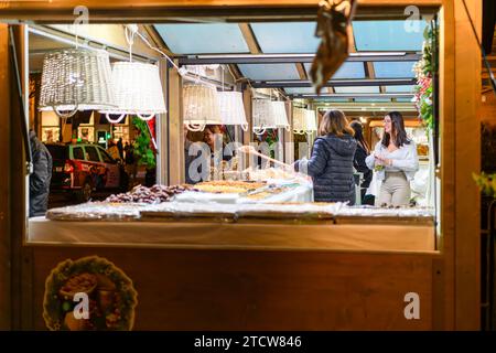 Abendansicht der Weihnachtsdekoration und der Essensstände auf dem Weihnachtsmarkt in Rossio im Stadtteil Baixa in Lissabon, Portugal. Stockfoto