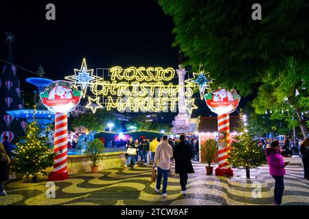 Abendansicht der Weihnachtsdekoration und der Essensstände auf dem Weihnachtsmarkt in Rossio im Stadtteil Baixa in Lissabon, Portugal. Stockfoto