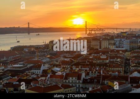 Blick bei Sonnenuntergang auf das Heiligtum Christi des Königs Monument und Statue mit Blick auf den Tejo und die Brücke Ponte 25 de Abril vom Alfama-Viertel Stockfoto