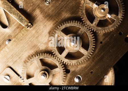 Zahnräder aus Messing befinden sich auf der Rückseite einer Tischuhr. Nahaufnahme mit Vintage Uhrwerk Stockfoto