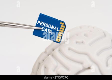 Ein Mann steckt eine Speicherkarte in sein Gehirn mit der Aufschrift "persönliche Daten". Geschäfts- und Technologiekonzept. Stockfoto
