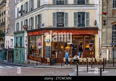 Ein Mann, der vor dem Le Progrès, einem Bistro und Café in Montmartre im ht e18 Arrondissement von Paris, Frankreich, Tee serviert hat Stockfoto