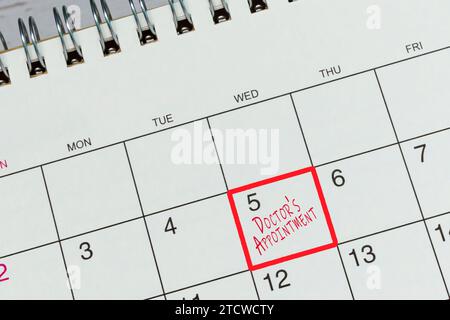 Rote Markierung auf dem Kalender um 5 Uhr zur Erinnerung an den Arzttermin. Stockfoto