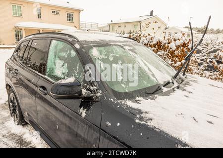 Blick auf ein Auto in Eis und Schnee, mit erhöhten Scheibenwischern an einem kalten Wintertag. Schweden. Stockfoto