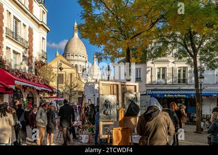 Leute, die an einem Winternachmittag in Montmartre, Paris, Frankreich, spazieren um den Place du Tertre herum und schauen sich die Künstler und ihre Werke an Stockfoto