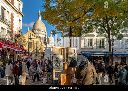 Leute, die an einem Winternachmittag in Montmartre, Paris, Frankreich, spazieren um den Place du Tertre herum und schauen sich die Künstler und ihre Werke an Stockfoto