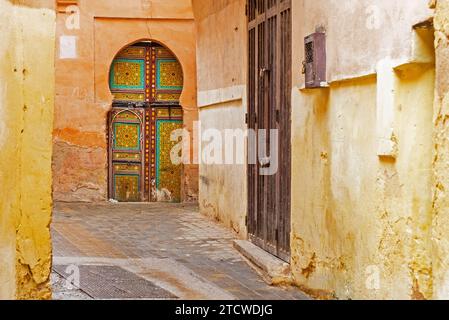 Maurisch dekorierte Tür in der Gasse der alten historischen gelben Medina der Stadt Meknes, Fez-Meknes, Marokko Stockfoto