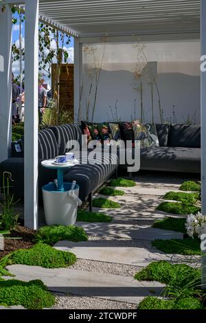 Terrace Retreat Garden (kleine moderne Terrasse, schattige Sitzplätze zum Entspannen, Stipa gigantea) - RHS Tatton Park Flower Show 2023, Cheshire, England, Großbritannien Stockfoto