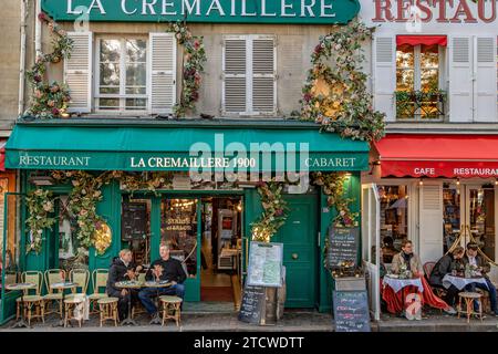 Personen, die am späten Nachmittag an einem Wintertag vor La Crémaillère 1900 sitzen, in Place du Tertre, Montmartre, Paris, Frankreich Stockfoto