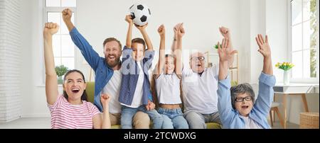 Freuen Sie sich, dass Großeltern, Eltern und Kinder im fernsehen Fußball-Sportspiele sehen. Stockfoto