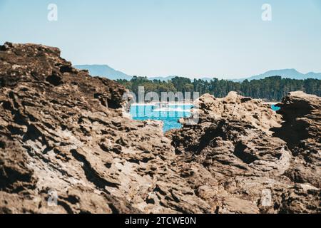 Das Boot fährt zwischen den Felsen im Wasser am Mount Maunganui Beach, Neuseeland. Stockfoto