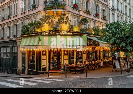 Tische und Stühle vor der La Villa des Abbesses ein französisches Restaurant/Bistro in der Rue des Abbesses, Montmartre im 18. Arrondissement von Paris Stockfoto