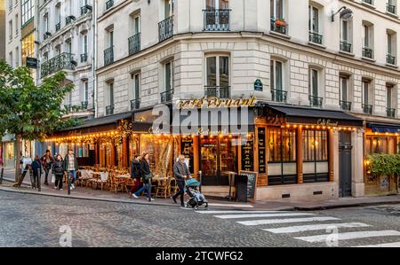 Leute gehen vorbei am Café Bruant, einem Restaurant/Café in der Rue des Abbesses in Montmartre im 18. Arrondissement von Paris, Frankreich Stockfoto