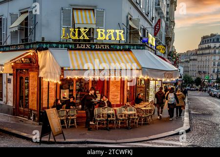 Ein Kellner serviert in der Lux Bar, einem Restaurant/Café in der Rue Lepic in Montmartre im 18. Arrondissement von Paris, Frankreich Stockfoto