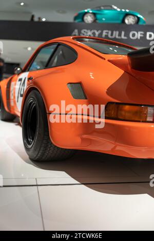 Foto des Autos von hinten und unten. Orangefarbener Porsche-Sportwagen. Stockfoto