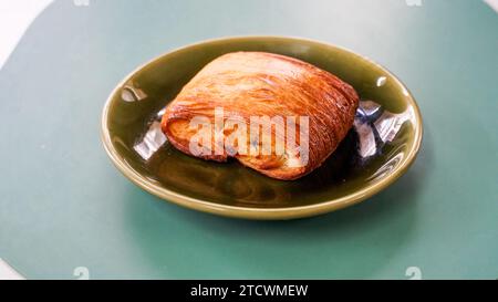 Frisch gebackene süße Brötchen Blätterteig mit Schokolade und Croissants. Pain au Chocolate auf einem Teller auf einem Kaffeetisch im Freien. Ein Pain au Chocolate, sein fla Stockfoto