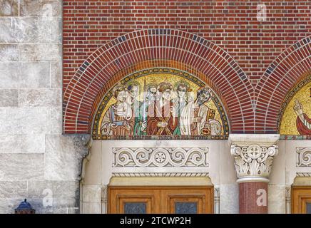 Mosaike und Buntglas unterstreichen die Fassade der 35th Avenue der St. Joan of Arc römisch-katholische Kirche, Teil des Jackson Heights Historic District. Stockfoto