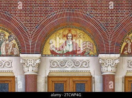 Mosaike und Buntglas unterstreichen die Fassade der 35th Avenue der St. Joan of Arc römisch-katholische Kirche, Teil des Jackson Heights Historic District. Stockfoto