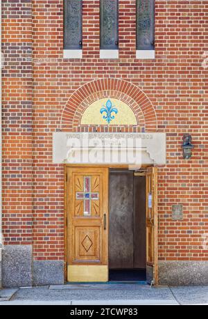 Mosaike und Buntglas unterstreichen die Fassade der 35th Avenue der St. Joan of Arc römisch-katholische Kirche, Teil des Jackson Heights Historic District. Stockfoto