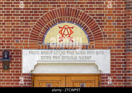 Mosaike und Buntglas unterstreichen die Fassade der 35th Avenue der St. Joan of Arc römisch-katholische Kirche, Teil des Jackson Heights Historic District. Stockfoto