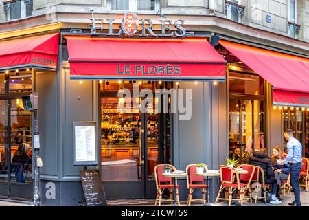 Die Leute sitzen an einem Tisch draußen auf der Terrasse im Le Florès, einem französischen Restaurant, Café in der Rue du bac im 7. Arrondissemin Paris, Frankreich Stockfoto