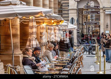 Die Leute sitzen auf der Terrasse des Le Nemours, einer schicken Brasserie mit Terrasse in der Nähe des Palais Royal, Paris, Frankreich Stockfoto