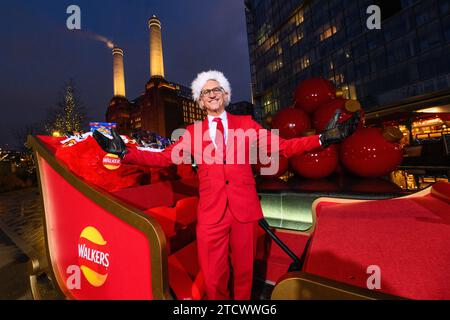 NUR REDAKTIONELLE VERWENDUNG Gary Lineker überrascht die Öffentlichkeit, indem er einen Schlitten voller Walkers-Crisps durch die Battersea Power Station im Süden Londons fährt, während er als „Father Crisp-MAS“ gekleidet ist, um sein 30. Jahr bei der Arbeit mit der Marke zu feiern. Bilddatum: Donnerstag, 14. Dezember 2023. Stockfoto