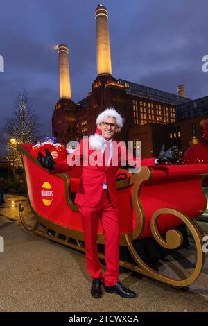 NUR REDAKTIONELLE VERWENDUNG Gary Lineker überrascht die Öffentlichkeit, indem er einen Schlitten voller Walkers-Crisps durch die Battersea Power Station im Süden Londons fährt, während er als „Father Crisp-MAS“ gekleidet ist, um sein 30. Jahr bei der Arbeit mit der Marke zu feiern. Bilddatum: Donnerstag, 14. Dezember 2023. Stockfoto