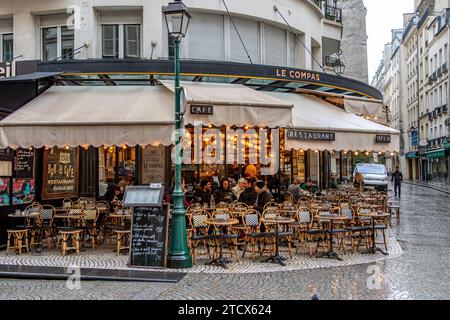 Die Leute sitzen draußen auf der Terrasse des französischen Restaurants Le Compas in der Rue Montorgueil, Paris Stockfoto