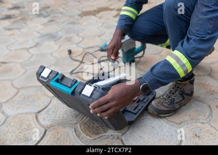 Nahaufnahme eines afrikanischen Klempners, der seine Werkzeuge nach einem Arbeitstag wegbringt. Stockfoto