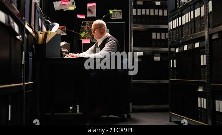 Privatdetektiv liest Akten, überprüft forensische Beweisberichte über geheime Dokumente im Vorfallsraum. Der Anwaltsbeamte, der Ermittlungsdienste mit Zeugenaussagen durchführt, entdeckt Hinweise. Stockfoto