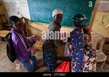 NAIROBI, Afrika. Dezember 2023. Frauen, die Weihnachtskleidung überprüfen, verteilt von Family Care Mission in der orthodoxen katholischen Kirche in Nairobi, Kenia. Die Einwohner von Kibera Slum erhielten Weihnachtsgeschenke von Family Care Missions (einer seit 2001 registrierten Wohltätigkeitsorganisation in Kenia, die sich aus voll- und Teilzeit-Freiwilligen zusammensetzt, die ihre Zeit und ihre Anstrengungen für die Unterstützung von Unterprivilegierten und Benachteiligten der Gesellschaft widmen. Ihre Freiwilligen suchen lohnende Projekte aus, um das Bewusstsein für die „Ärmsten der Armen“ zu schärfen und sie zu unterstützen. FCM bietet Dienstleistungen wie die Beschaffung von Mitteln für Schulessen, Stockfoto