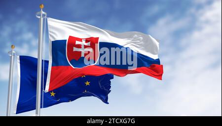 An klaren Tagen winken die Flaggen der Slowakei und der Europäischen Union im Wind. Die Slowakei ist Mitglied der Europäischen Union und der Eurozone. 3D Abbildung Stockfoto