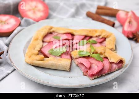 Köstliche Apfelgalette mit Minze auf weißem Marmortisch, Nahaufnahme Stockfoto