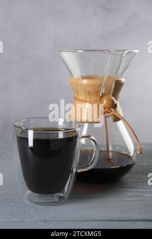 Kaffeemaschine aus Glas und chemex mit leckerem Tropfkaffee auf grauem Holztisch Stockfoto