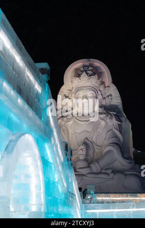 HARBIN, CHINA - 1. Januar 2022: Vertikale Abbildung der spektakulären beleuchteten weißen Eisskulpturen beim Harbin Ice and Snow Festival in Harbin, Hei Stockfoto