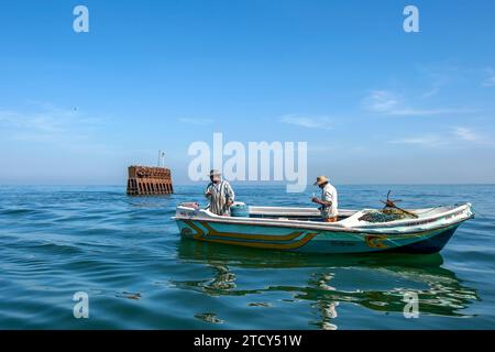 Männer in einem Boot fangen Fische in der Nähe des Schiffswracks vor Negombo Beach an der Westküste Sri Lankas. Stockfoto