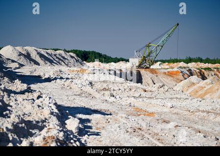 Der wandelnde Bagger wird in der Nähe von Pfahlreihen in der Bergbaugrube betrieben Stockfoto