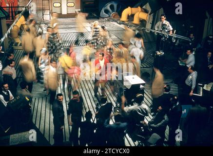 NEW YORK, NY – 1957: Die US-amerikanische Sängerin Perry Como (1912–2001) steht auf der Bühne, während die Ray Charles Singers um ihn herum tanzen und singen während der Perry Como Show um 1957 in New York. (Foto von Hy Peskin) *** örtliche Unterschrift *** Perry Como Stockfoto