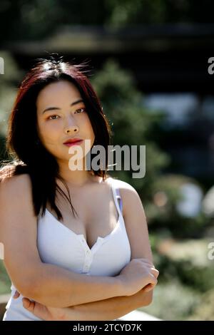 Schöne junge Frau kurvige Athletik, die an einem sonnigen Tag in einem Garten steht Stockfoto