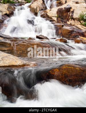Majestätischer Wasserfall fällt über glatte Felsbrocken im Rocky Mountain National Park. Stockfoto