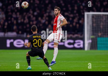 AMSTERDAM, NIEDERLANDE - 14. DEZEMBER: Petros Mantalos (AEK Athene) und Josip Sutalo (Ajax) kämpfen um den Ball während der Gruppe B - UEFA Europa League Stockfoto