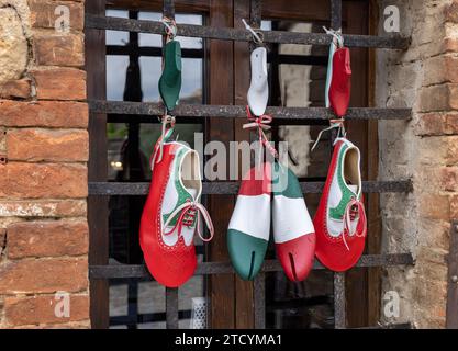 Monteriggioni, Italien - 17. September 2022: Dekoration eines Schuhgeschäfts in Retro-Atmosphäre und Nationalfarben Italiens in Monteriggioni. Toskana. Stockfoto
