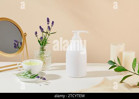 Im Badezimmer befindet sich eine Flasche Duschgel mit Spiegel, Teetasse, Kerzen und Lavendelblumen. Ätherisches Lavendelöl hat viele ef Stockfoto