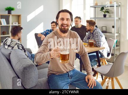 Eine Gruppe glücklicher Freunde trinkt gemeinsam zu Hause Bier Stockfoto