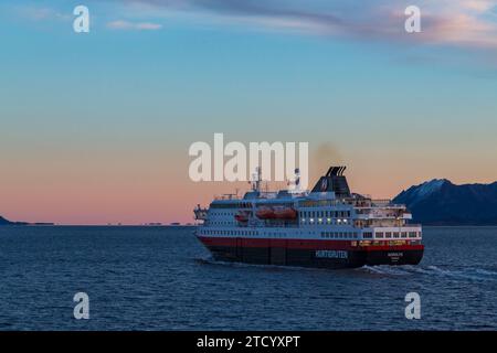 Hurtigruten Nordlys Kreuzfahrtschiff im frühen Morgenglühen des Sonnenaufgangs in Norwegen, Skandinavien, Europa im Oktober Stockfoto